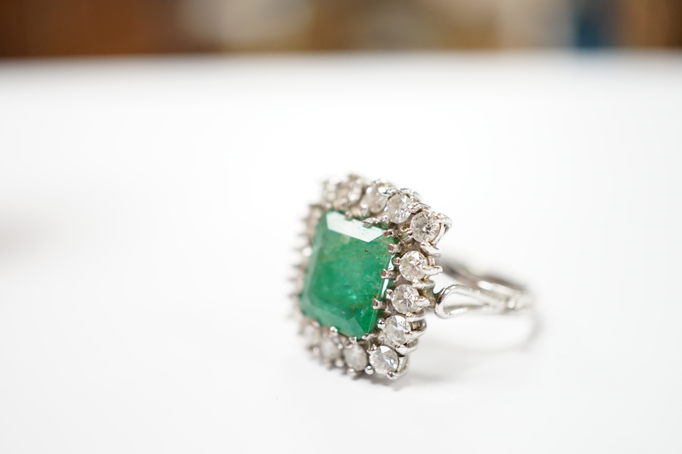 A white metal, emerald and diamond set square cluster ring, size I, gross weight 6.3 grams.